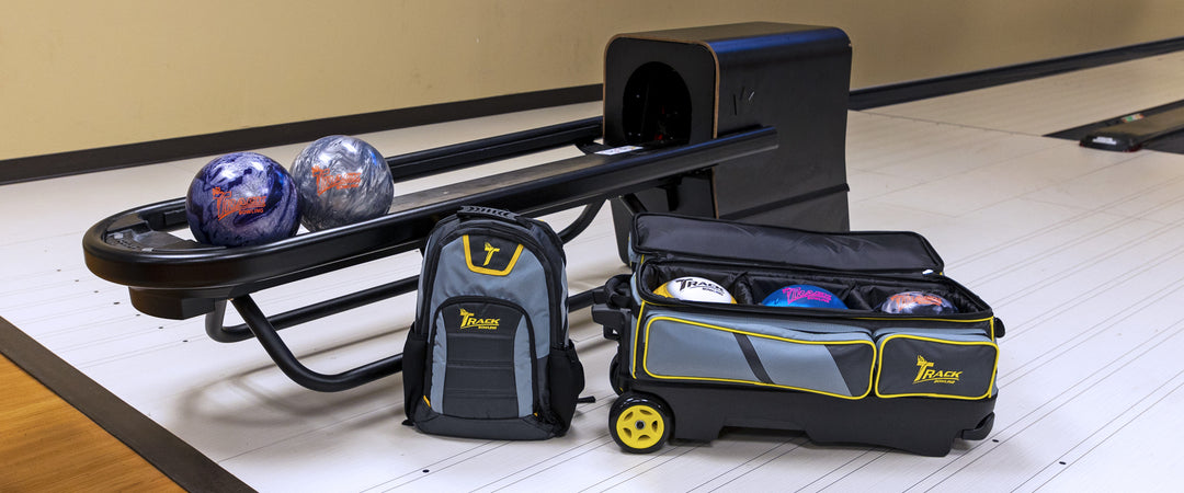 Track Bowling backpack and triple roller with balls inside next to ball return with two ball in rack.